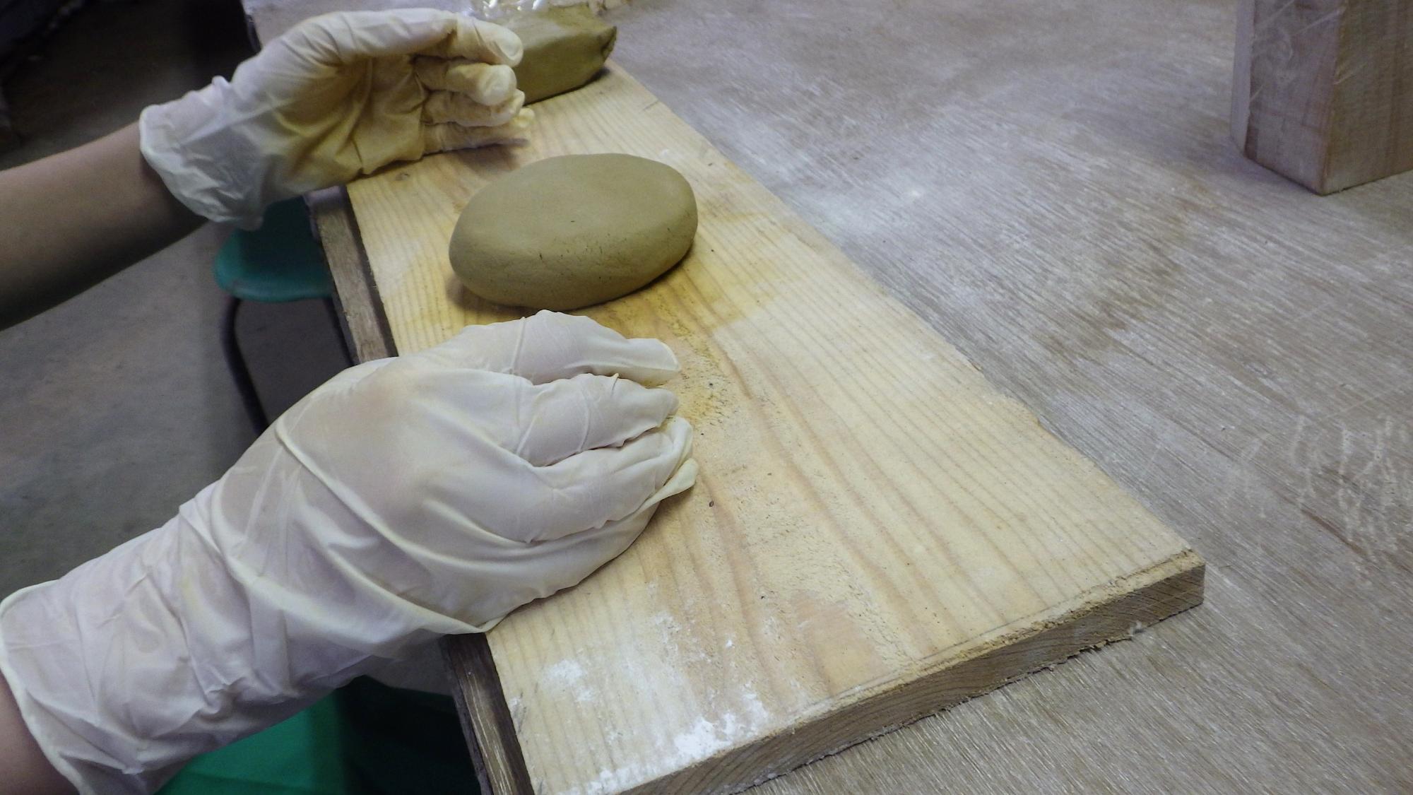 木の板の上に丸く成形された粘土が置かれている写真