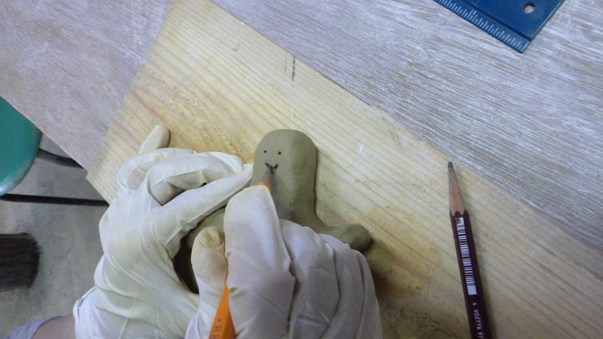 粘土に顔を描く人の手元の写真