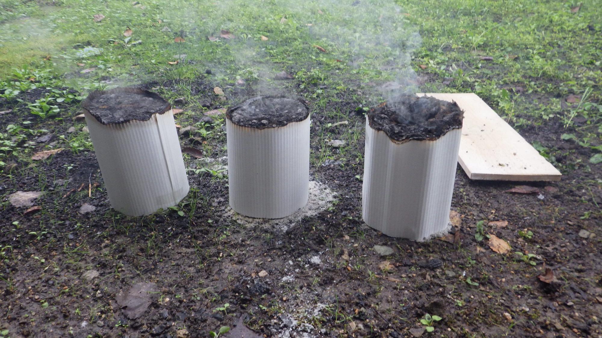 上部が燃え尽きた3つの白い筒の写真