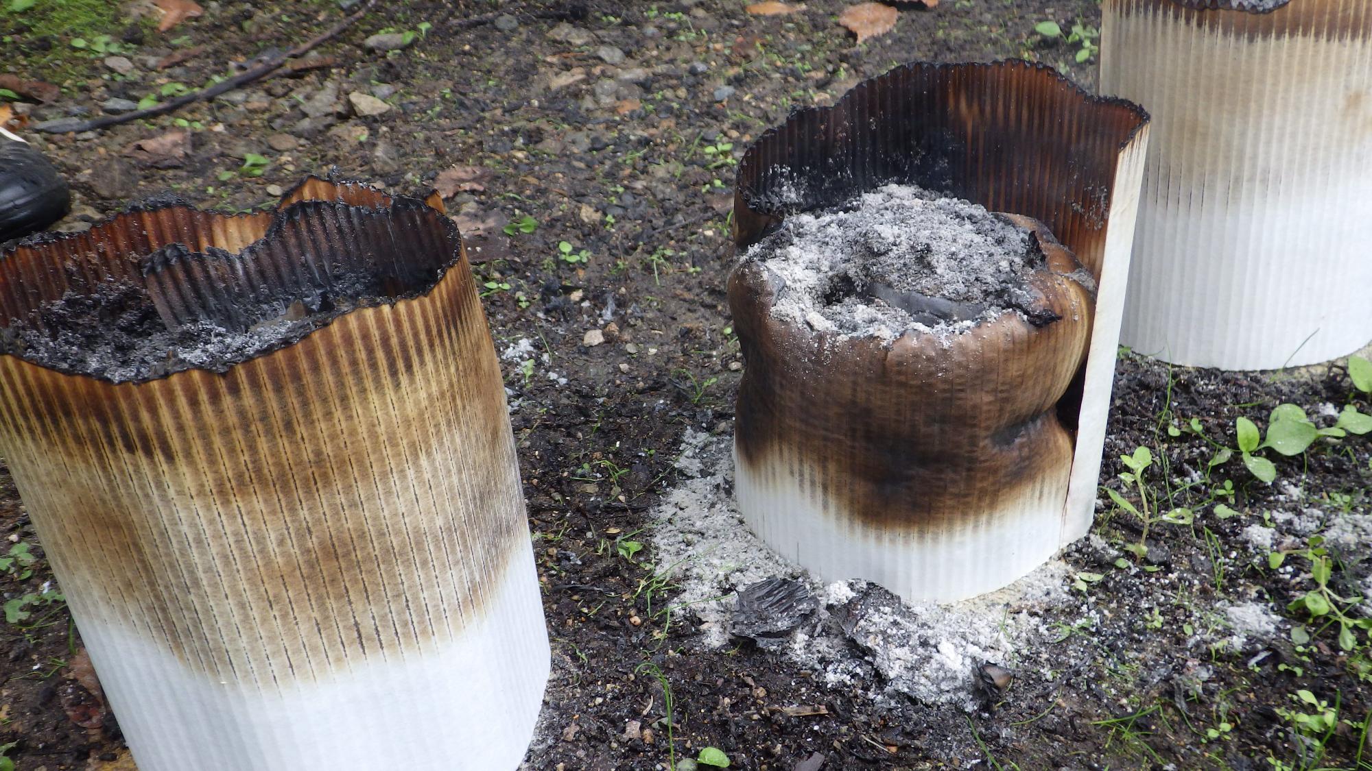 焼け焦げた灰と白い筒の写真