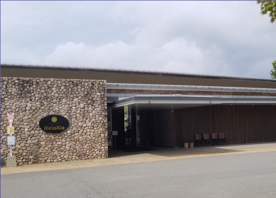 「RelaXia」と書かれた石の壁がある建物の写真