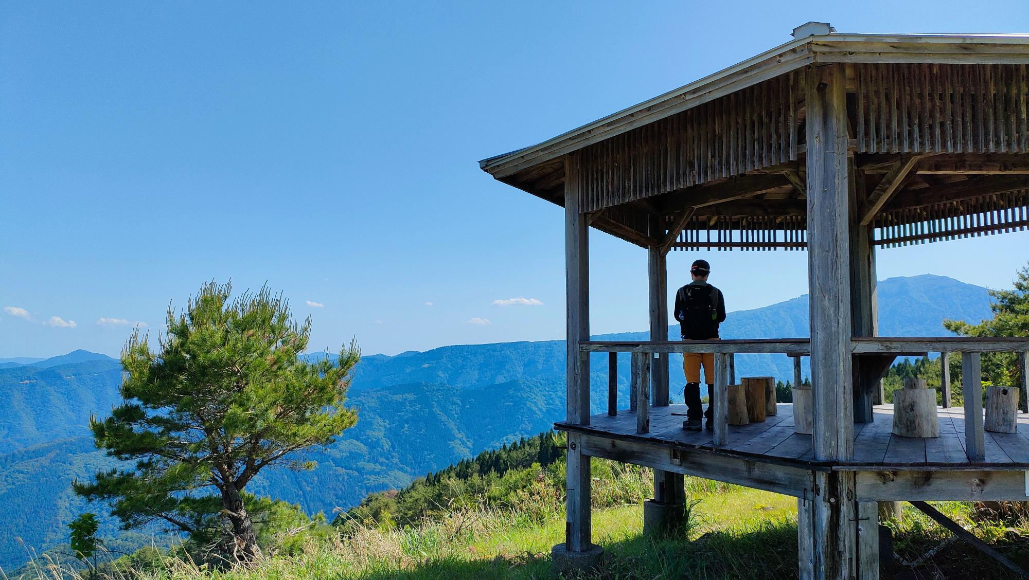 高台に設置された6角形屋根付きデッキに立つ人の写真