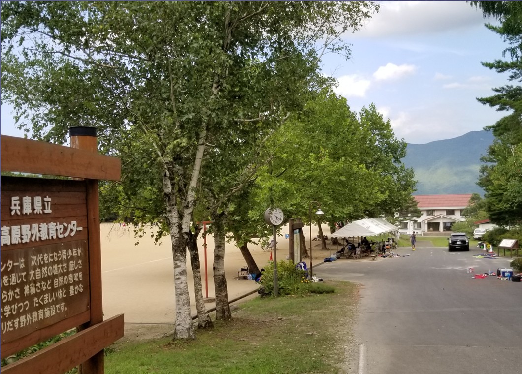 手前に案内板が立っており道が奥まで続いている写真