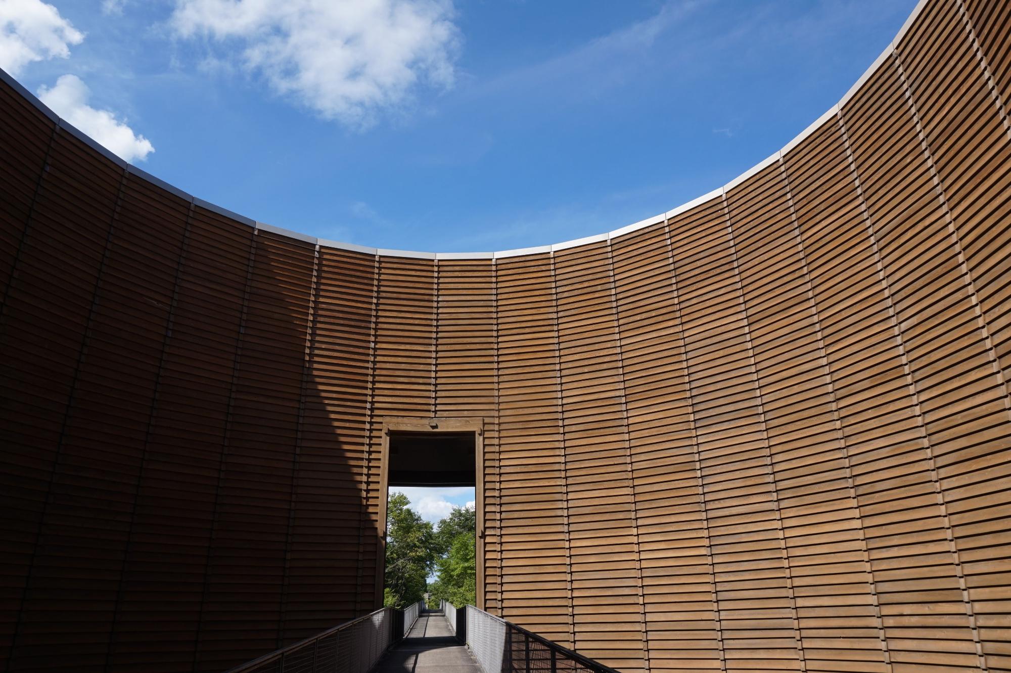 木製の壁面が円形にカーブした建造物の写真