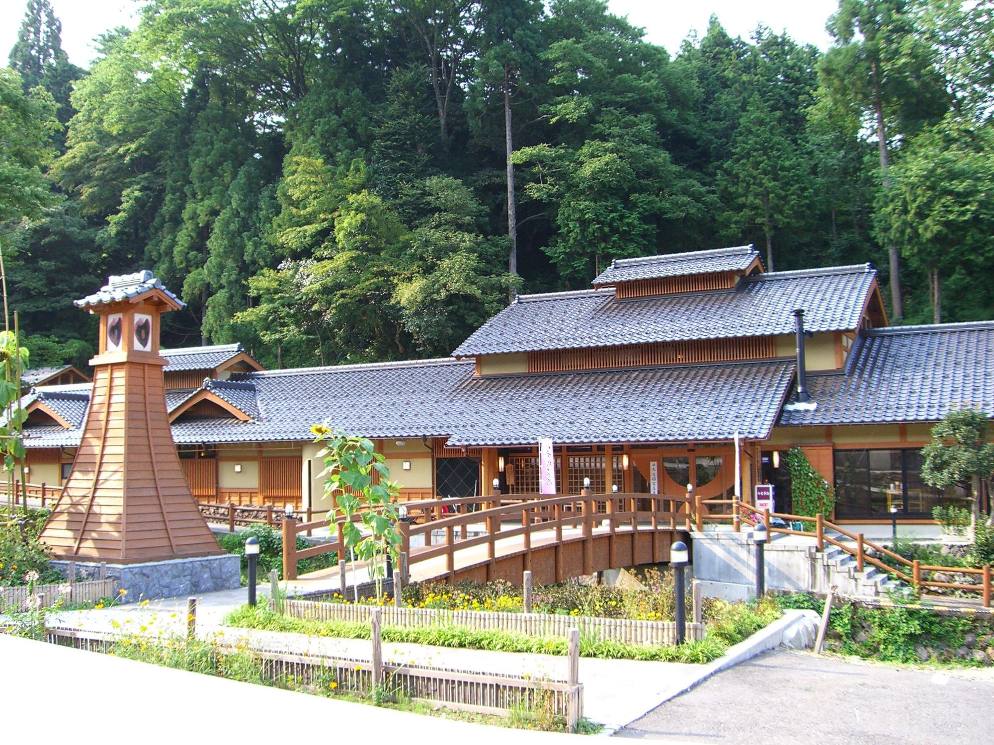 瓦屋根の建物の入り口前に橋が架かっている写真