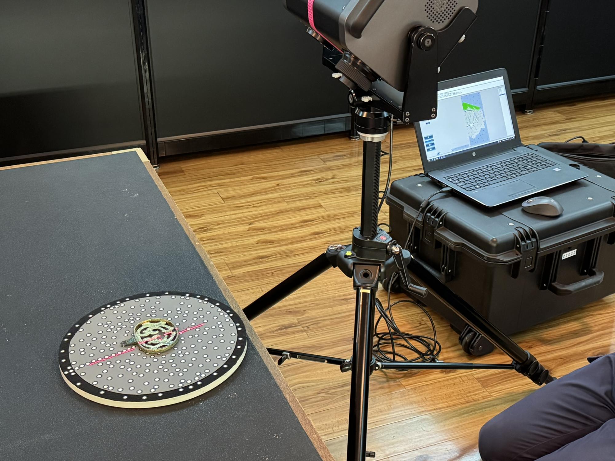 三脚の付いた機器がパソコンとコードでつながっている写真