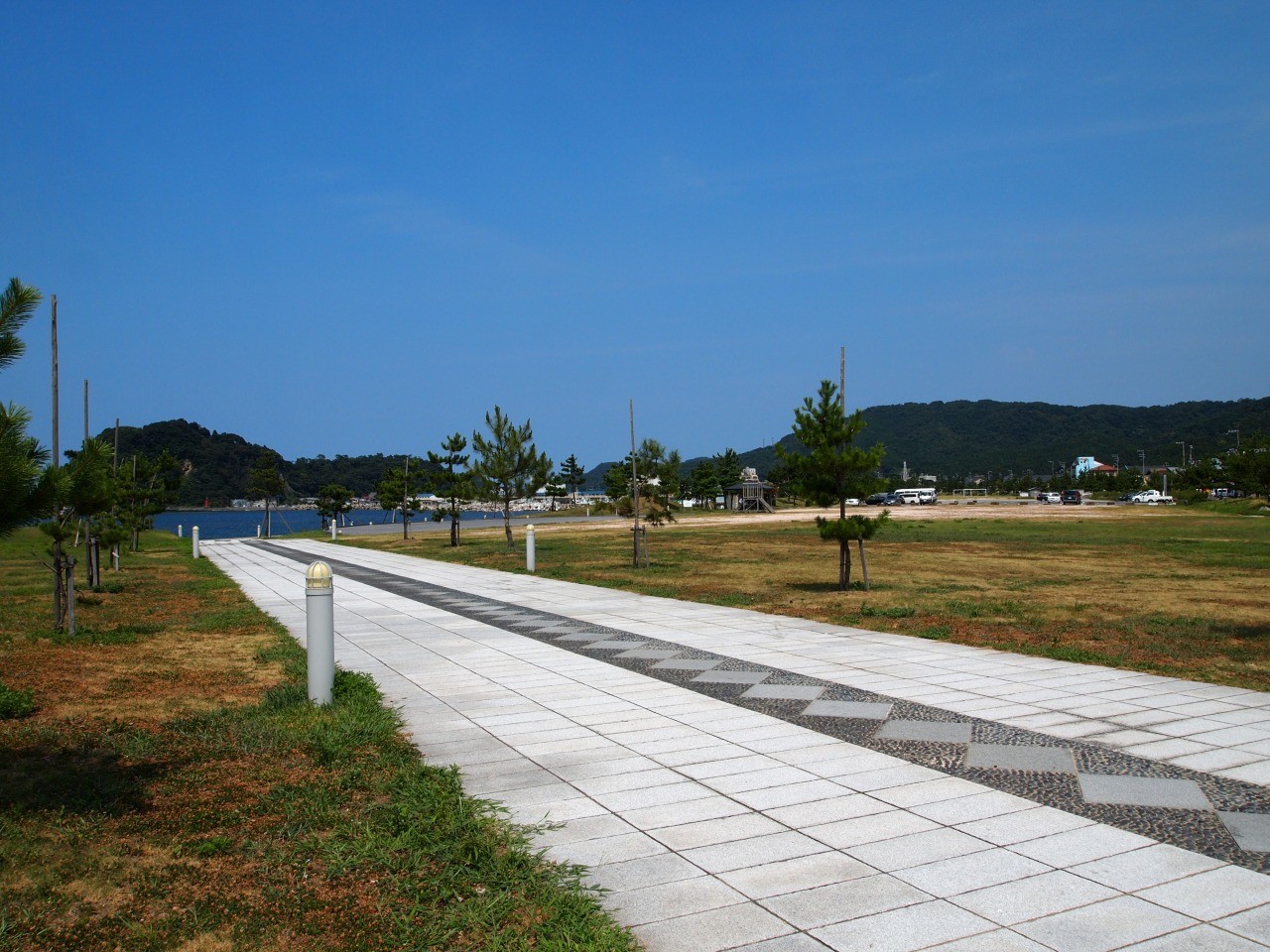 芝生の広場に石のタイルで作られた道が作られている写真