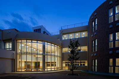 夜に撮影された大きなガラス張りの窓がある校舎外観の写真