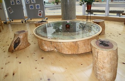 木の切り株風の丸テーブルとスツールが並ぶくつろぎスペースの写真