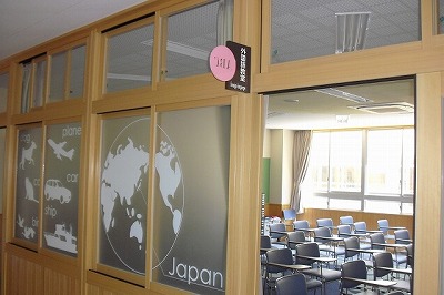 外国語教室の入口とたくさんの椅子が並んで配置されている教室内の写真