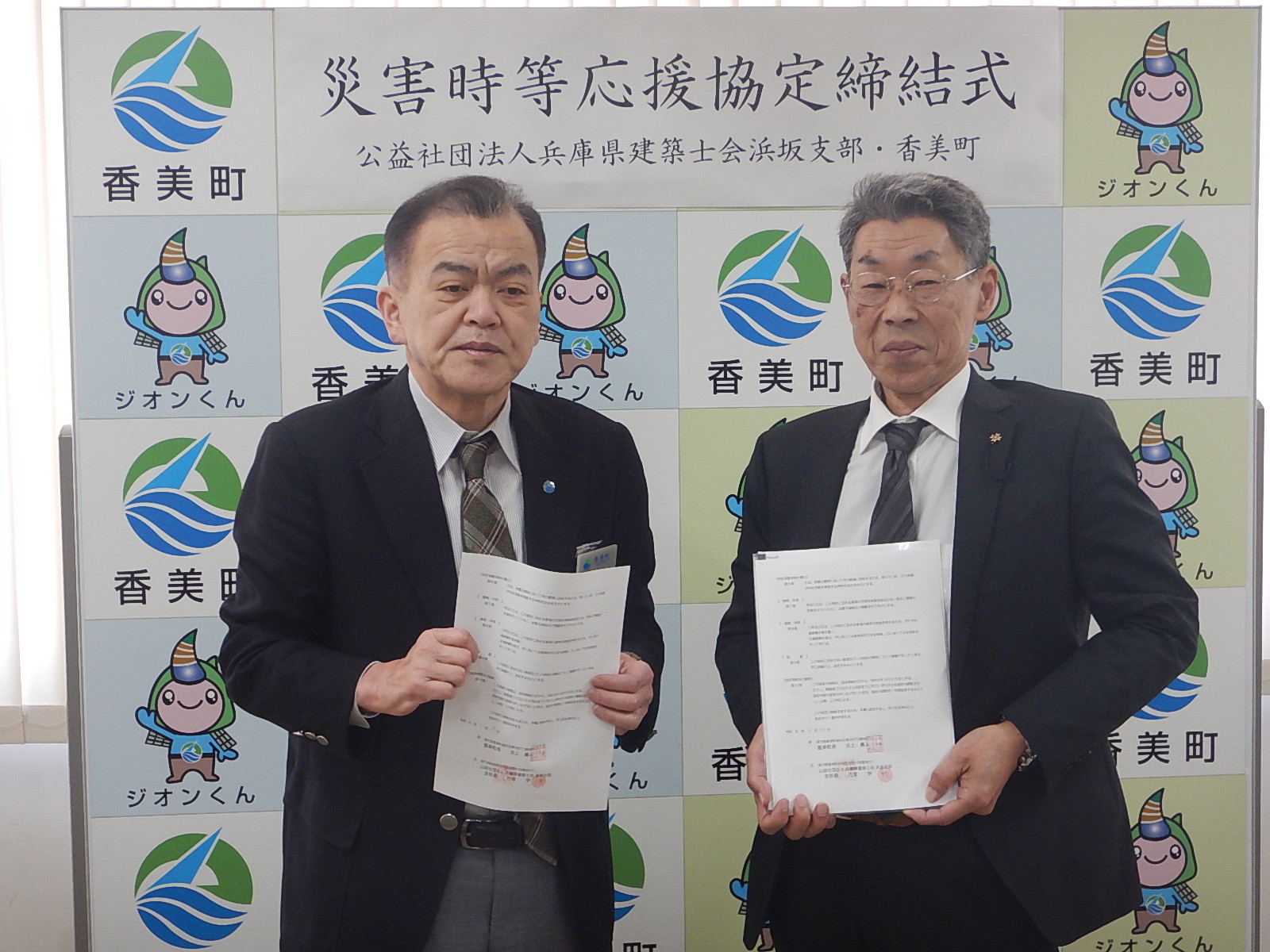 香美町長と兵庫県建築士会浜坂支部が書類を両手に持って一緒に写っている写真