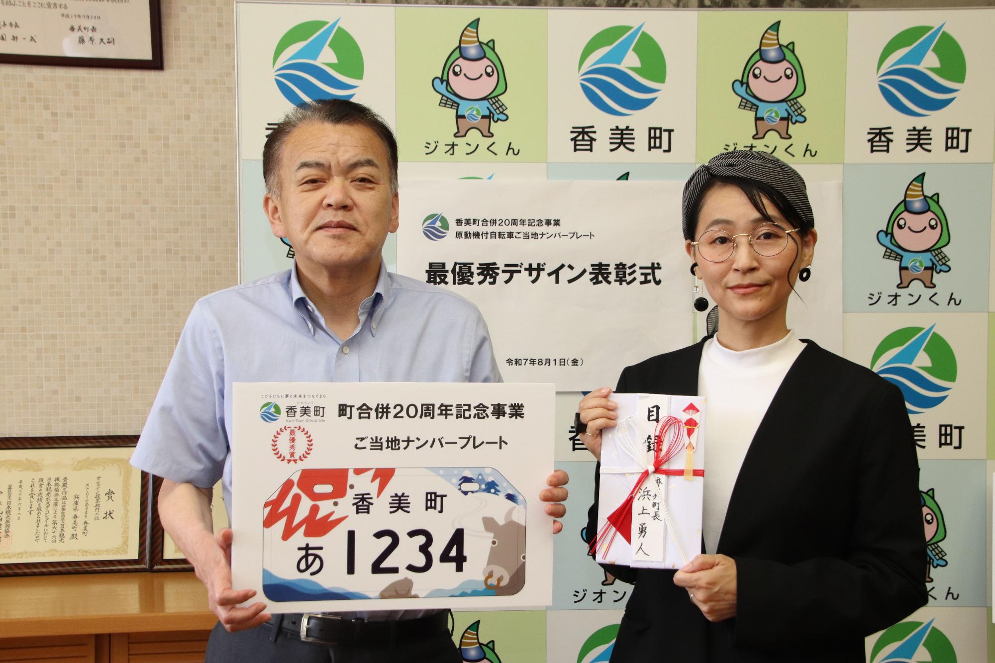 2人の男女がナンバープレートのデザインと目録を持っている写真