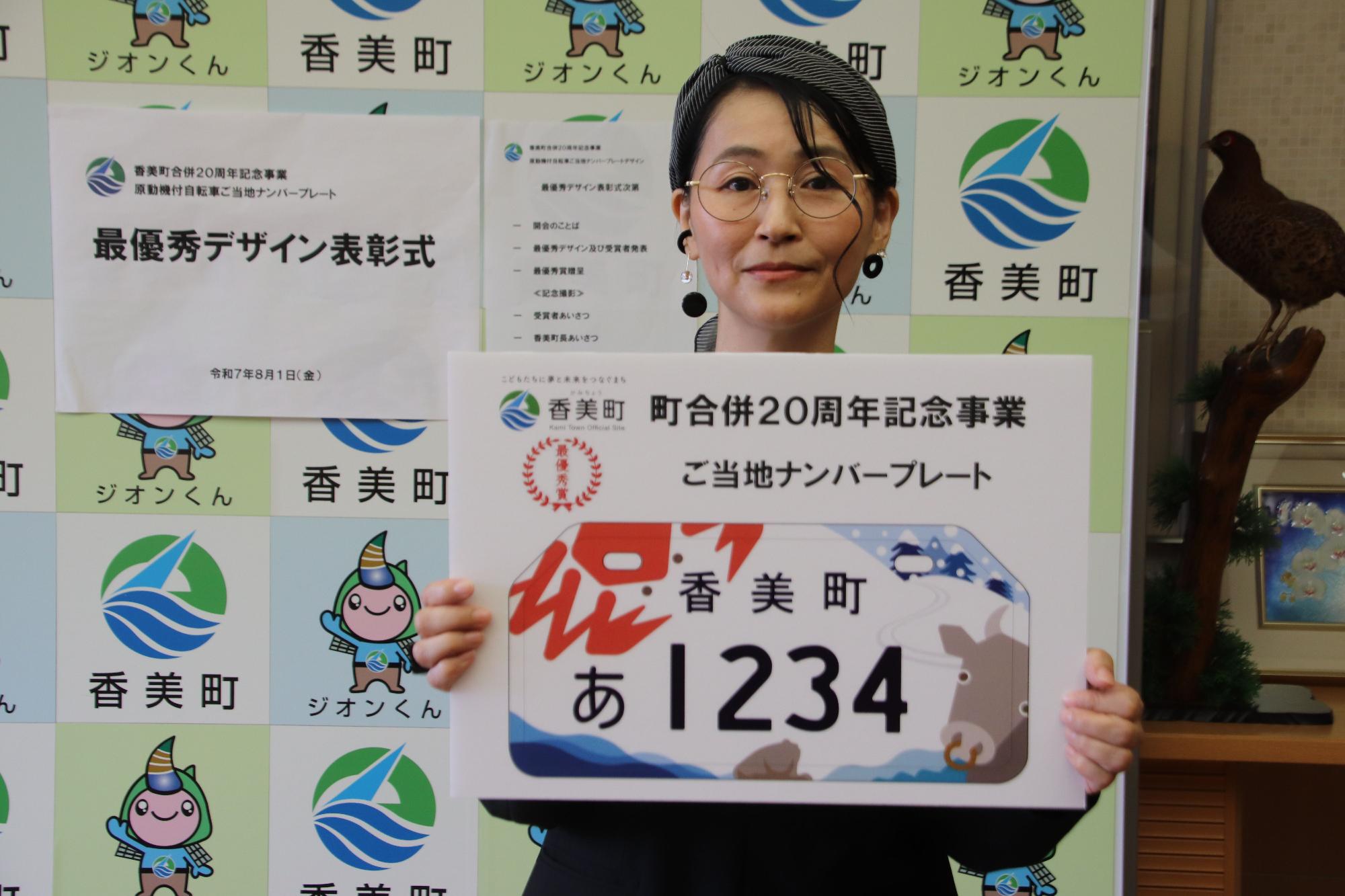 女性がナンバープレートのデザインを持っている写真