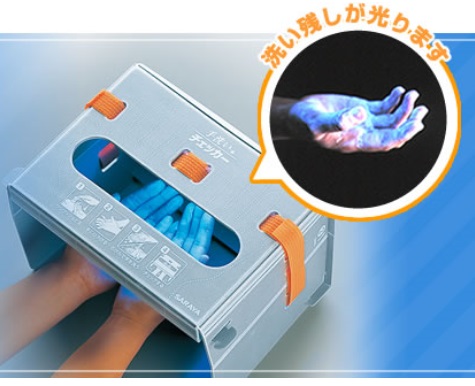 青白く光った右手と「洗い残しが光ります」と書かれた吹き出しと灰色の小型の機械に両手を入れている写真